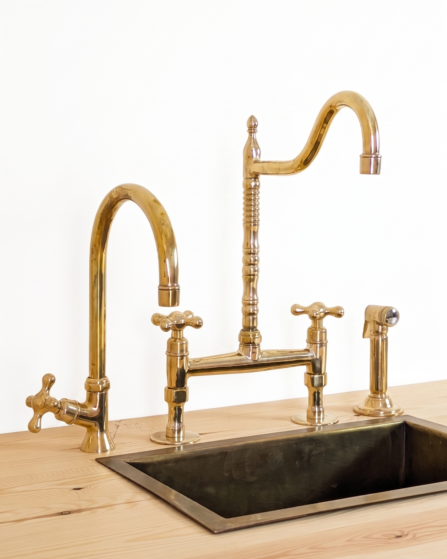 Unlacquered Brass Bridge Faucet  With a Side Sprayer and a Separate Cold Water Faucet.