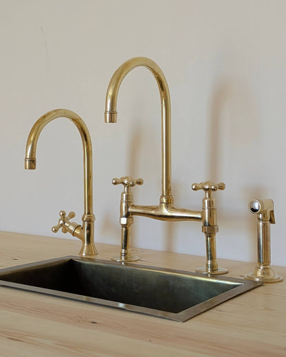Unlacquered Brass Bridge Faucet  With a Side Sprayer and a Separate Cold Water Faucet.