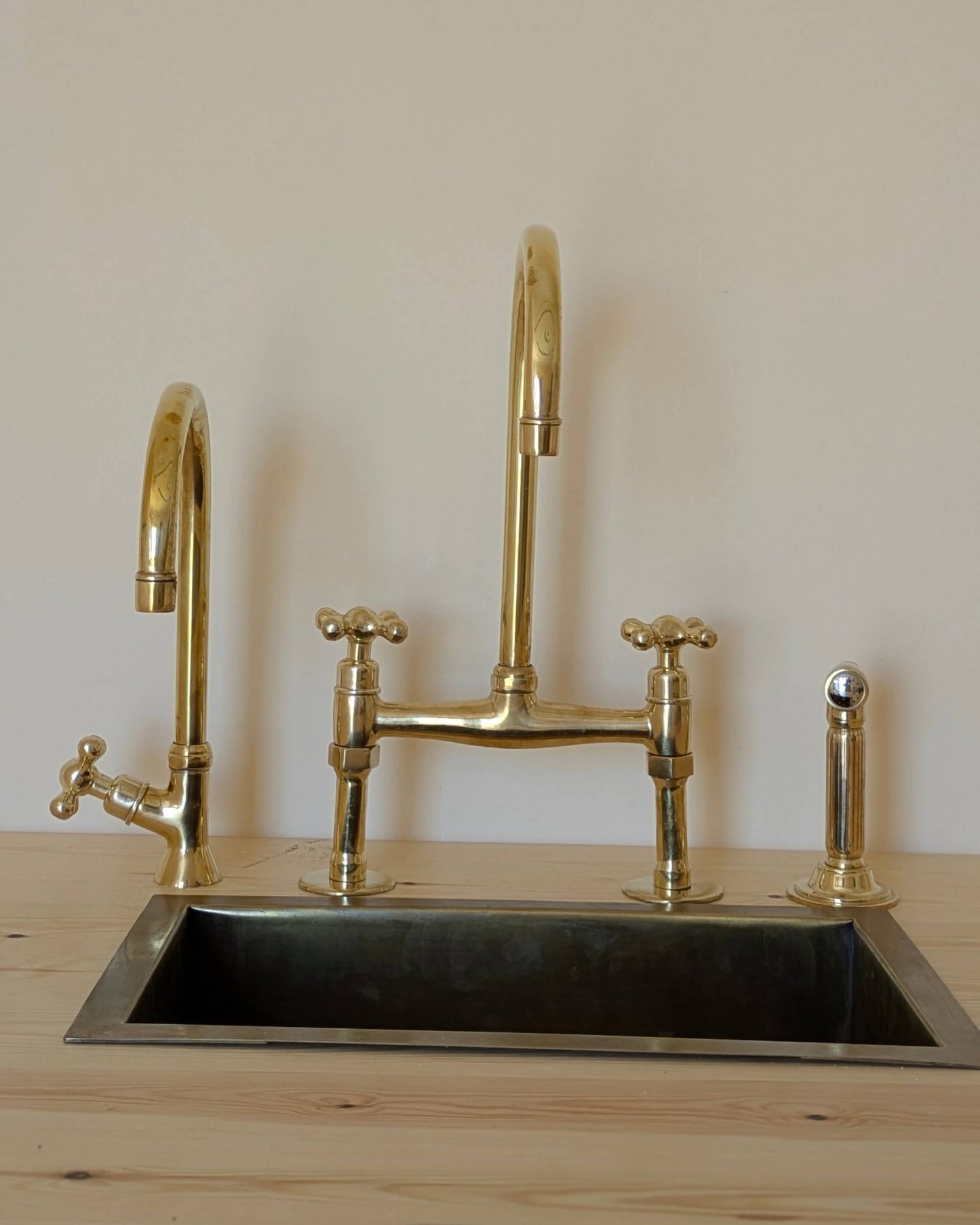 Unlacquered Brass Bridge Faucet  With a Side Sprayer and a Separate Cold Water Faucet.