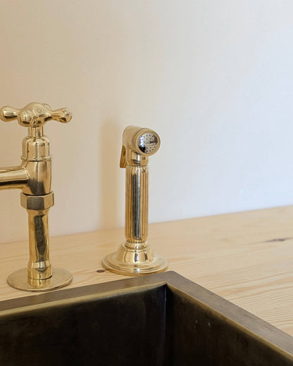 Unlacquered Brass Bridge Faucet  With a Side Sprayer and a Separate Cold Water Faucet.
