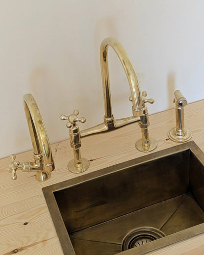 Unlacquered Brass Bridge Faucet  With a Side Sprayer and a Separate Cold Water Faucet.
