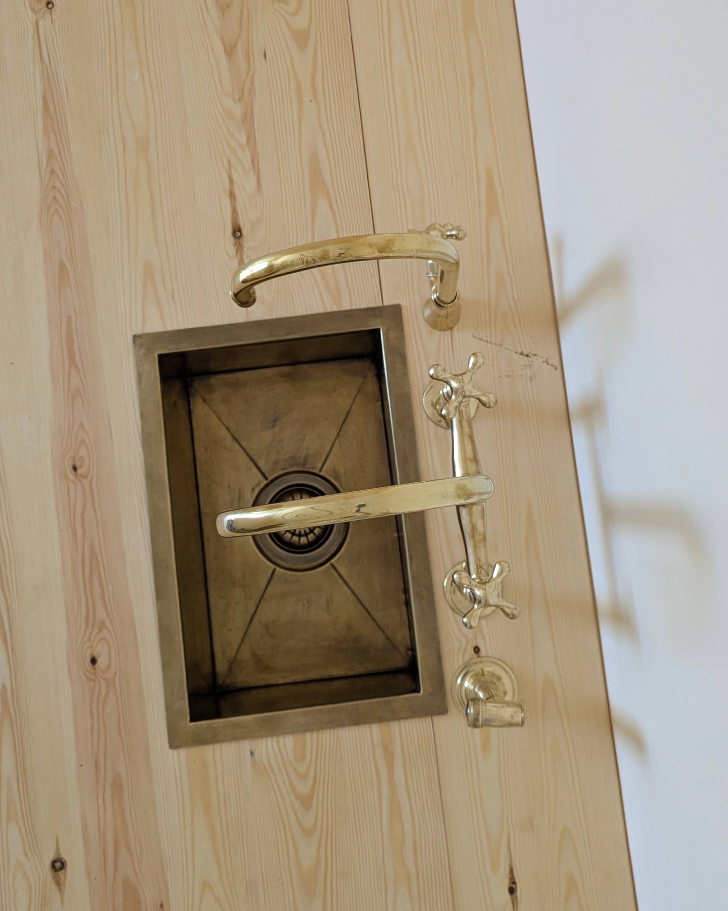 Unlacquered Brass Bridge Faucet  With a Side Sprayer and a Separate Cold Water Faucet.