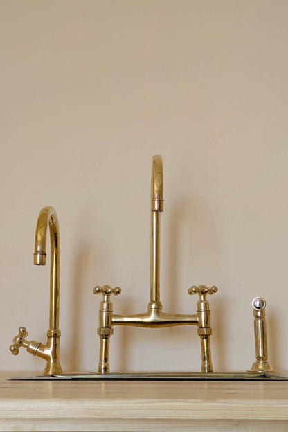 Unlacquered Brass Bridge Faucet  With a Side Sprayer and a Separate Cold Water Faucet.