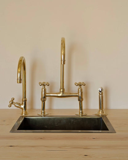 Unlacquered Brass Bridge Faucet  With a Side Sprayer and a Separate Cold Water Faucet.