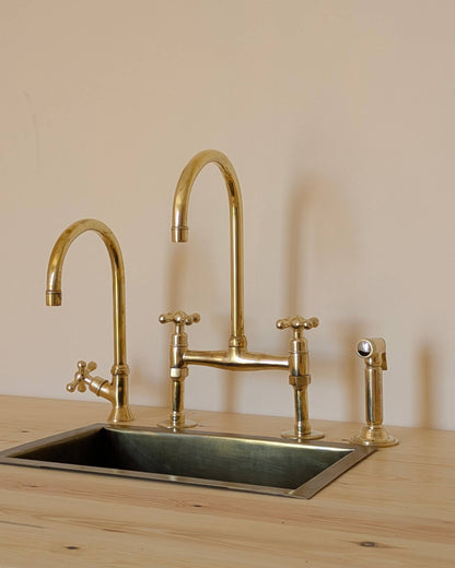 Unlacquered Brass Bridge Faucet  With a Side Sprayer and a Separate Cold Water Faucet.