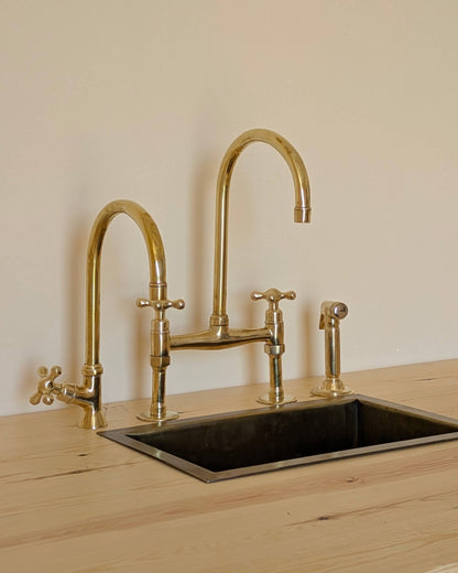 Unlacquered Brass Bridge Faucet  With a Side Sprayer and a Separate Cold Water Faucet.