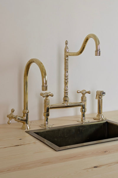 Unlacquered Brass Bridge Faucet  With a Side Sprayer and a Separate Cold Water Faucet.